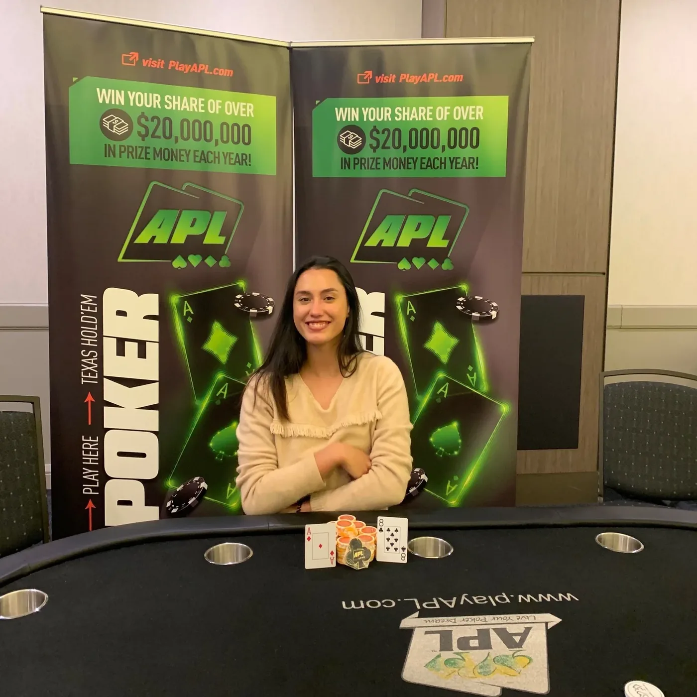 The author smiling at a poker table in front of Asia Poker League banners